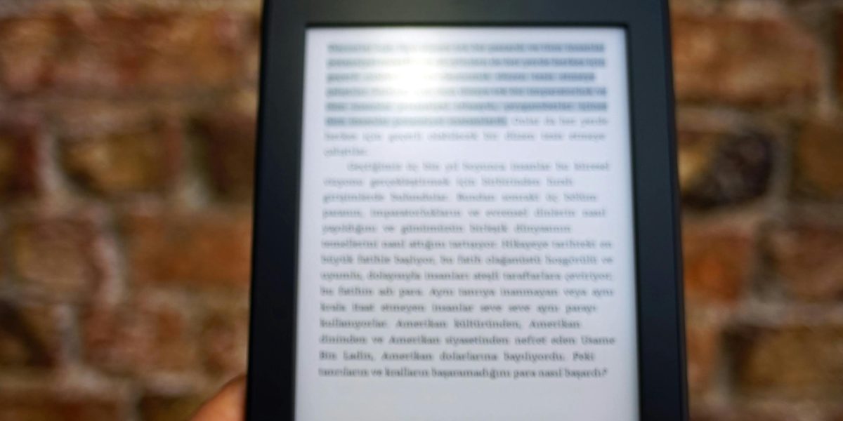 A reader enjoying a book on a tablet or e-reader in a comfortable, relaxed setting.