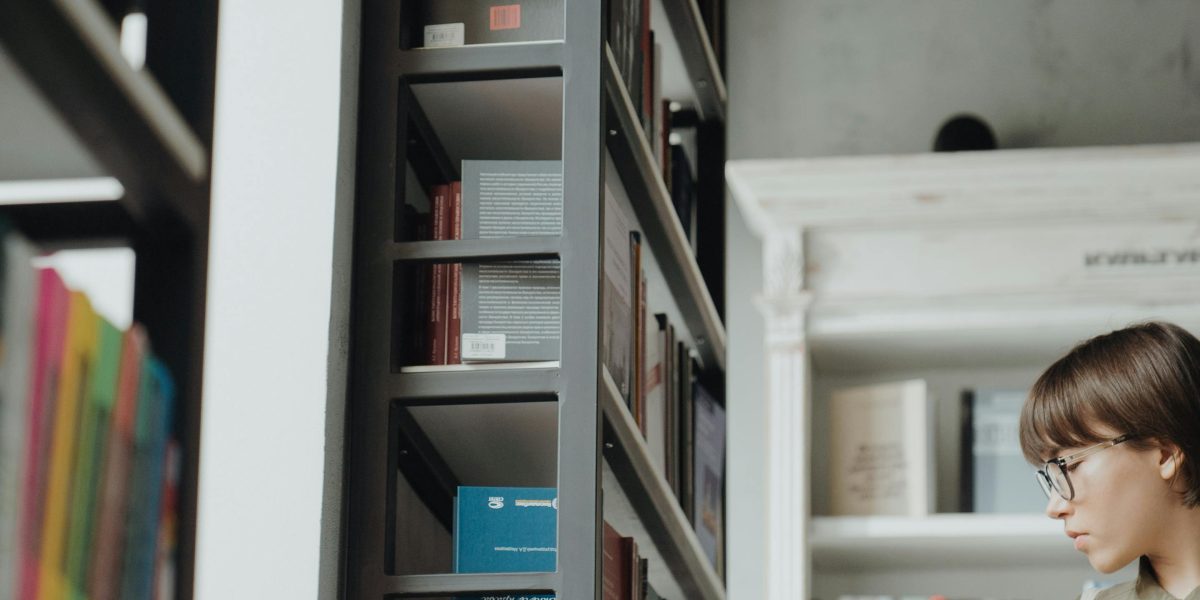 A person looking thoughtful, surrounded by many books, contemplating their next read with slight confusion.