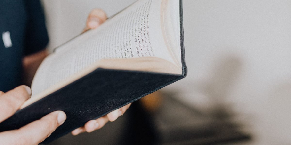 A reader lost in the imaginative world of a book, reflecting the dreamlike quality of Carroll's stories.