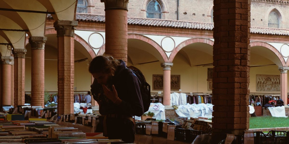 A person with a curious expression, sifting through old books in a library, symbolizing the joy of discovering hidden literary gems.