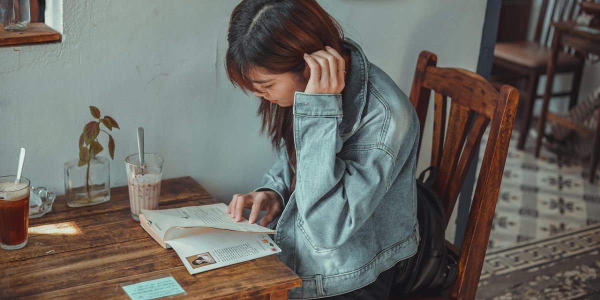 Immersing in a cozy fantasy story amidst the comforting ambiance of a cafe.