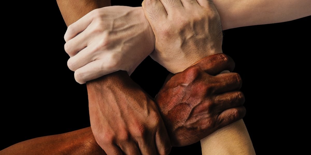 A diverse group of individuals working together, symbolizing teamwork and mutual support.